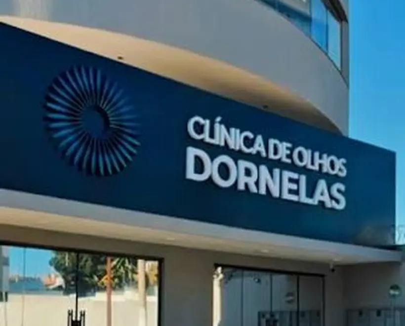 Fachada da Clínica de Olhos Dornelas vista da rua, com o letreiro azul sobre a entrada de vidro.